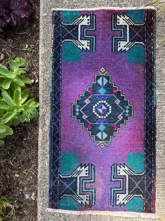 Vintage mini wool rug with geometric tribal motifs in electric iris purple, navy, turquoise, blush, and magenta tones measuring 1’8” x 3’3”.